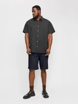 Short chino azul marino de lino y algodón, corte relajado, cintura media con elástico y cordón ajustable, bolsillos frontales y traseros.
