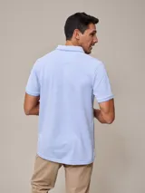 Chomba manga corta color beige con cuello clásico y tapeta de dos botones. Tiene un pequeño logo bordado en el pecho. Corte clásico.