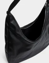 Bandolera hobo color gris claro, de cuerina, con manija superior y cierre superior.