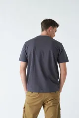 Remera color ocre de corte recto y manga corta, con cuello redondo y estampado rectangular con diseño floral en el frente.