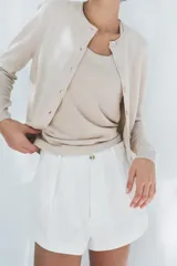 Top color crema de punto liso con escote redondo y sisa.