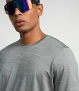 Remera deportiva gris de jacquard con cuello redondo y manga corta. Presenta estampa abstracta y tecnología Dry.