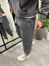 Pantalón de jogging gris con efecto lavado, corte holgado y puños ajustados.