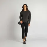 Sweater gris oscuro de punto tricotado con cuello redondo y mangas largas. Tiene aberturas laterales con cadena dorada.