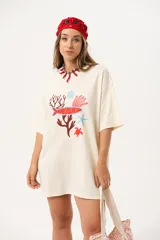 Remerón color crema de algodón con estampado de motivos marinos en tonos rojo y azul. De calce oversize y largo extendido.