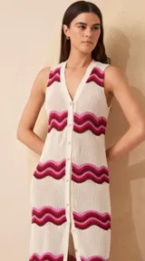 Vestido largo de punto con diseño de ondas en color crudo, rosa y bordó. Tiene escote en V, botones frontales y cartera en el delantero.