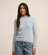 Suéter de punto color blanco, con cuello alto y mangas largas, confeccionado en tejido de peluche.