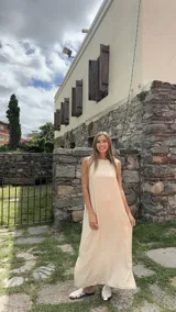 Vestido largo color crema, sin mangas y de corte recto.