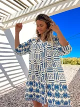 Vestido camisero corto de algodón con estampado de guardas geométricas en azul y blanco, con cuello en V y mangas cortas.