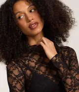Blusa de encaje negro con cuello alto y mangas largas.