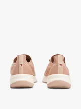 Zapatillas de estilo running con exterior de punto elástico color beige, diseño de corte bajo con ajuste estilo calcetín y cierre de cordones. Presenta el logo de Tommy Hilfiger bordado en el lateral y suela de goma blanca.