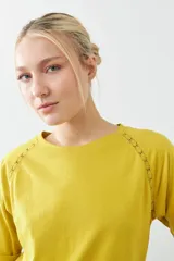 Remera color verde pistacho, de corte recto y manga corta raglán con detalle de vainillas en los hombros.