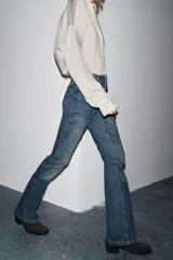 Pantalón de jean azul oscuro, de tiro bajo, corte slim fit y bootcut. Con cinco bolsillos y cierre frontal con cremallera y botón.