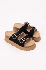 Sandalias con plataforma color marrón, doble tira en símil gamuza, costuras decorativas en blanco y hebillas metálicas doradas.