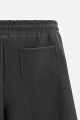 Bermuda negra de corte relaxed fit, con cintura elástica ajustable con cordón, bolsillos frontales y bolsillo trasero de parche.