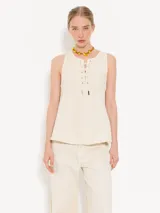 Musculosa color crema con escote con cordones cruzados.