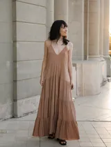 Vestido largo color beige, tipo solera, acampanado con vuelos en la falda y breteles finos.