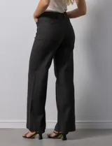 Pantalón de jean blanco de pierna ancha, tiro alto, pretina con pasadores, botón y cierre. Delantera y trasera con bolsillos.