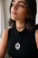 Collar con dije plateado en forma de espiral y cordón negro encerado.