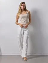 Pantalón cargo de lino color blanco, marca Marissa Olivia. Tiene pretina ancha elastizada con lazo de ajuste, bolsillos inclinados delanteros y bolsillos laterales con botón.