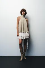 Top de cuello halter color beige, con lazada tipo foulard, forro interior y cierre lateral con cremallera oculta.
