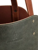 Bolso matero tipo tote bag Hush Puppies, color verde con base marrón y herrajes dorados. Tiene doble asa de hombro marrón.