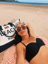 Bolso de playa grande de lona color crema con base negra y asas de soga negras. Estampado frontal con la frase "Beach Please" en letras negras.
