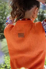 Chaleco tejido calado color crema, con cuello redondo y sisas amplias.