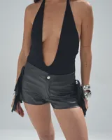 Short negro de cuero sintético con flecos en los laterales.