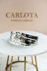 Pulsera rígida plateada de acero quirúrgico con textura martillada.