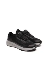 Championes Umbro modelo Adventure para hombre, color negro con detalles en gris oscuro. Presentan una capellada de malla transpirable con refuerzos sintéticos y la marca Umbro en relieve sobre el lateral. La suela es gruesa, de color gris claro, con una base negra.