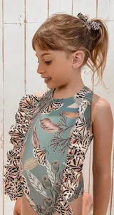 Traje de baño entero con estampado de hojas y mariposas, con volados en los hombros y moño para el pelo haciendo juego.