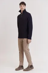 Sweater de punto color crema con cuello alto y cierre de cremallera parcial. Diseño de corte holgado y mangas largas.