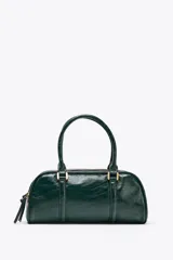 Bolso tipo bowling color verde oscuro charolado, con doble asa de mano y correa bandolera extraíble. Tiene doble compartimento con cierre de cremallera.