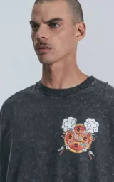 Remera negra con efecto acid wash, corte holgado y estampa frontal con diseño alusivo a Disney.