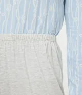 Conjunto de pijama largo de dos piezas en tejido de punto suave. La blusa es de manga larga con cuello en V y detalle de encaje. El pantalón es de corte recto con cintura elástica.