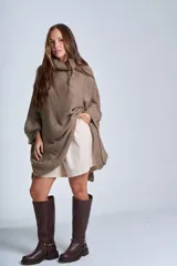 Poncho polerón negro tejido con cuello alto y mangas 3/4.