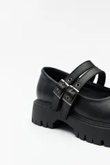 Guillerminas blancas de cuero sintético con suela track negra y doble tira ajustable con hebillas metálicas.
