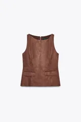 Top marrón de efecto gamuza, con cuello redondo, sin mangas, bolsillos frontales con solapa y cierre metálico en la espalda.