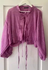 Camisa color ciruela de lino con mangas abullonadas y lazos frontales.