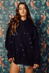 Buzo hoodie azul marino con lentejuelas plateadas y pequeños recortes en forma de corazón.