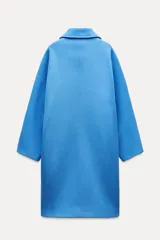 Abrigo amplio de Zara Woman Collection confeccionado en hilatura con mezcla de lana. Tiene cuello solapa, manga larga, bolsillos delanteros, forro interior a contraste y cierre frontal con botones.