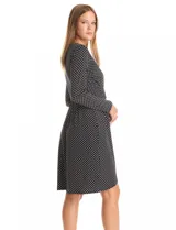 Vestido de seda fría marca Luxology, con estampado floral en blanco y negro. Presenta escote en V cruzado, cintura elastizada con apliques metálicos, manga larga y ruedo con corte asimétrico.