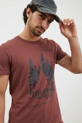 Remera verde militar de algodón con cuello redondo y manga corta. Estampado frontal con diseño de montañas y texto en color negro.
