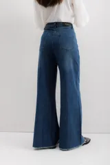 Pantalón de jean de corte ancho, color azul oscuro, con cintura alta y terminación desflecada.