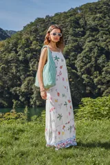 Vestido largo sin mangas de rayon estampado con palmeras, cócteles y sombrillas, corte evasé, con cuello recto y tirantes regulables.