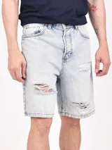 Bermuda de jean negro con roturas y corte a la rodilla.