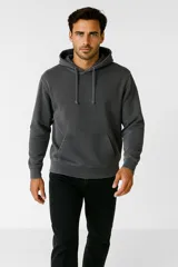 Buzo gris con capucha y cordones, de corte holgado y con bolsillo tipo canguro.