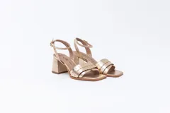 Sandalias de cuero color bronce con textura tipo cocodrilo, con tira delantera ancha y tira fina con hebilla al tobillo. El tacón es ancho y cuadrado.