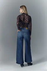 Pantalón de jean de corte oxford confeccionado en denim confort con elastano, lavado azul con desgaste localizado y bigotes. Tiro alto, con cierre y botón, pierna ancha desde la cadera. Cuenta con forrería en bolsillos estampada con logo de la marca.